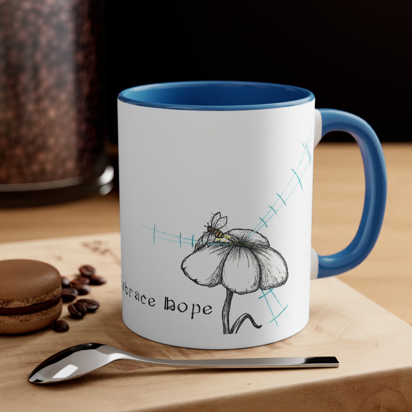 White Coffee Mug, Blue Inside, Blue Handle, Reject Certainty Embrace hope text, flower and bee image, sitting on a table